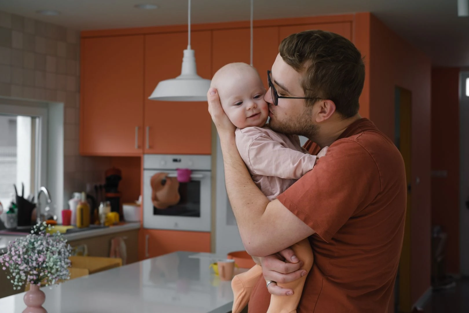 daddy_with_baby_girl_his_hands_cuddling_kitchen_home_taking_care.jpg